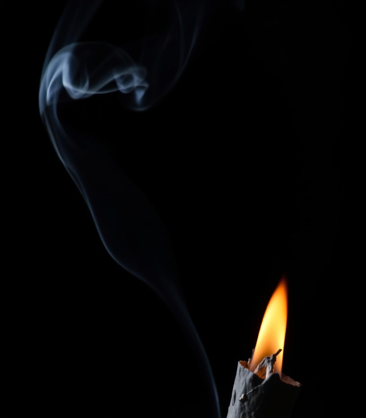 Sage smoke rising against a dark background